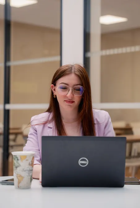 Étudiante concentrée travaillant sur son ordinateur au campus ECS de Reims